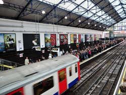 Tren del metro de Londres pasando por una estación en hora punta